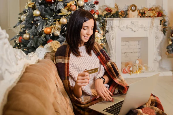 İnternetten noel alışverişi yapan, kredi kartı tutan bir kız.