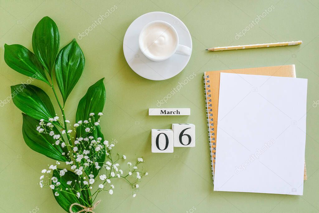 Wooden cubes calendar March 6. Open blank notepad, cup of coffee, bouquet flowers on green background. Concept hello spring Top view Flat lay Mock up