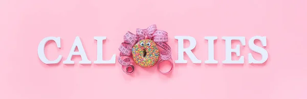 Las calorías del texto de las letras blancas y la mujer divertida abstracta hicieron la rosquilla con los ojos y los cabellos de la cinta del centímetro sobre el fondo rosado. Dieta o comida poco saludable concepto creativo Vista superior Flat lay Banner — Foto de Stock