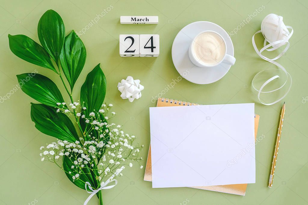 Wooden cubes calendar March 24. Notepad, cup of coffee, bouquet flowers on green background. Concept hello spring Creative Top view Flat lay Mock up.