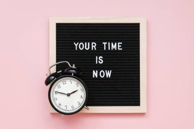 Senin zamanın geldi. Mektup panosunda motive edici bir alıntı ve pembe arka planda siyah alarm saati. Top view Flat Lay Concept, günün ilham verici alıntısıdır.