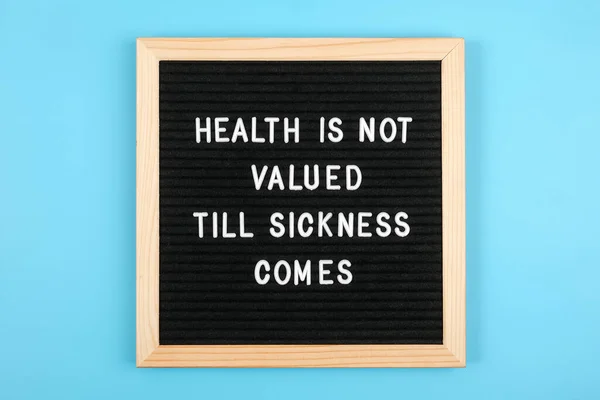 Health is not valued till sickness comes. Motivational quote on black letter board on blue background. Concept Health Care and Medicine, inspirational quote of the day.
