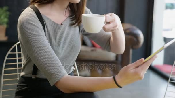 美しいトレンディな若い女性でメガネ座ってで A カフェ飲むエスプレッソ コーヒーと見て計算された笑顔と読書スローモーション撮影赤い叙事詩 8 k — ストック動画