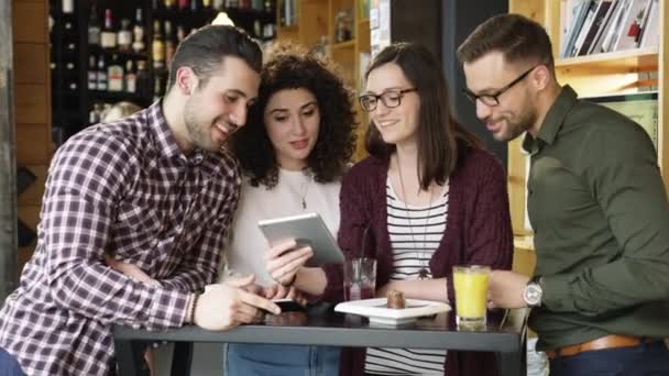 Kollegen diskutieren ein Projekt im Café mit Blick auf Tablet trendige Mitarbeiter Teamarbeit Kaffeehaus Restaurant zusammen Bau einer Start-up-Zeitlupe auf roten epischen 8k — Stockvideo