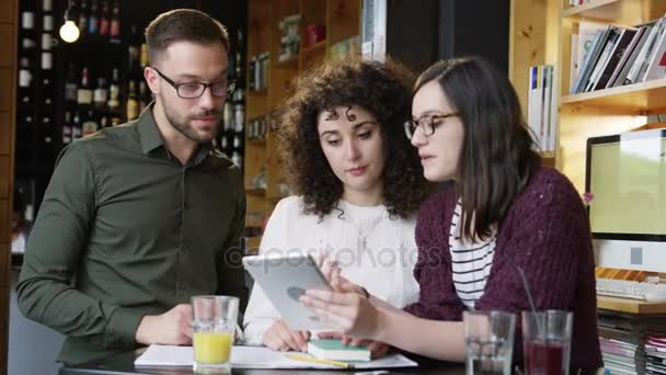 Módní spolupracovníky studenti při pohledu na Tablet plánování strategie pití kávy po spuštění Online podnikání konceptu Slow Motion Shot na Red Epic 8k — Stock video