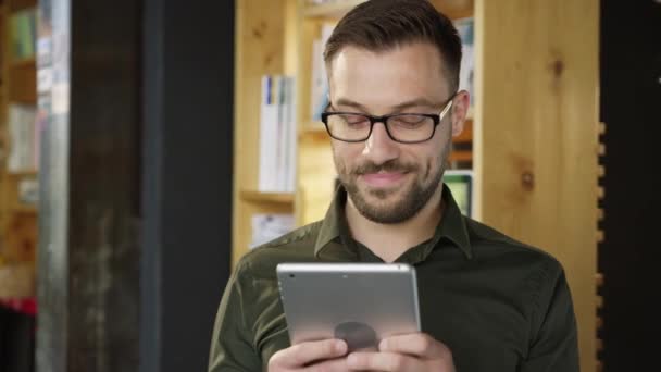 Guapo Joven Confiado Usando Una Tableta Sonriente Sonriente Mensajes de texto Divertidos Online Meme Video Relajante Ocio Tecnología Casual Concepto Lento Disparo En Red Epic 8K — Vídeo de stock