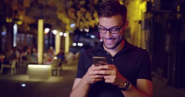 Hezký mužský Model pomocí aplikace na Smartphone zkoumání cestování umístění 4g 5g připojení City světle kytice zpomaleně snímek Red Epic 8k — Stock video