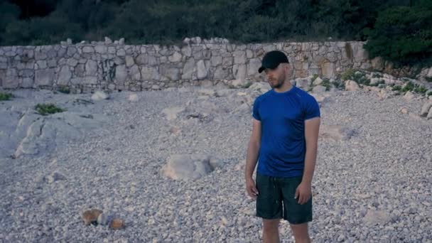 Depresyjny młody człowiek stojący na pustym brzegu plaży Samotność Depresja Myśli samobójcze Powolny ruch Fale kruszenie na skałach Dramatyczny smutek Tragedia Concept — Wideo stockowe