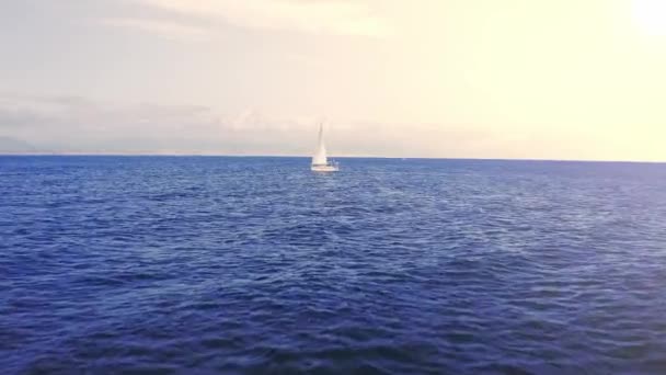 帆船在日落黄金时间驶过蓝水，驶向地平线航行夏季冒险假期的概念 — 图库视频影像