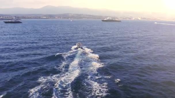 Bateau de vitesse naviguant à travers l'océan vers le rivage au coucher du soleil Lever du soleil Vacances méditerranéennes Europe France Riviera Holiday Adventure Concept — Video