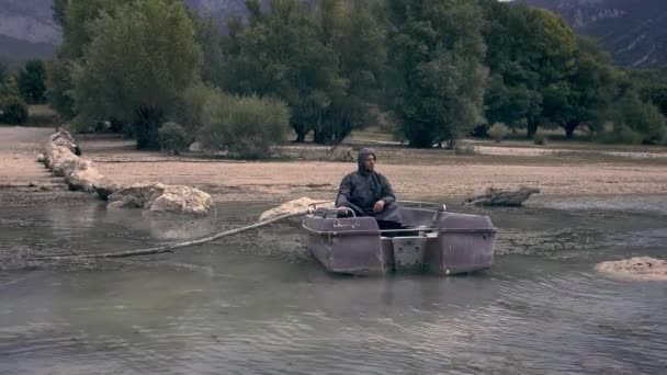 Hombre joven solitario sentado en barco de pesca en la costa del lago Depresión Tristeza Aislamiento Concepto de soledad Vuelo aéreo — Vídeos de Stock