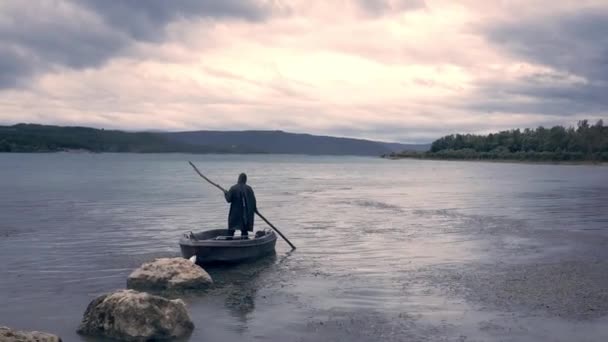 Aerial Of Man In A Hood Standing On A Deserted Shore Boat Holding Staff Fine dei tempi Cambiamento climatico Disastri naturali Mistero Fantasy Concetto di fiabe — Video Stock