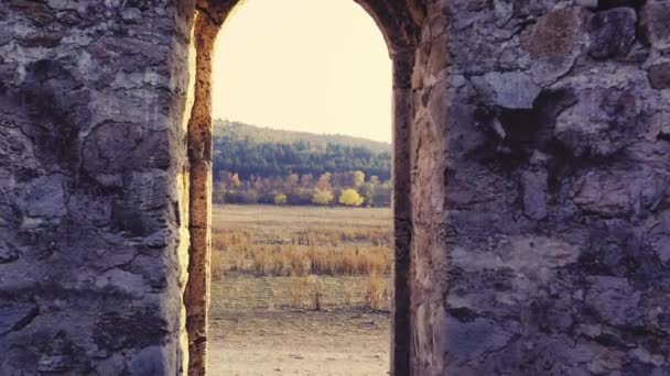 Passando attraverso la finestra abbandonata della chiesa del forte nel campo del tramonto nuovo inizio dopo il concetto di eternità di vita 4K di movimento lento — Video Stock