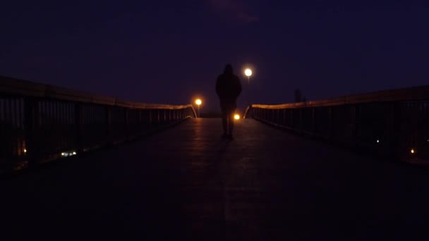 Silhouette di uomo triste che cammina sul ponte di notte Viaggi a distanza sociale Lento movimento 4K Raw — Video Stock