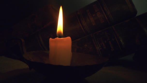 Stack Of Old Books For Research Illuminated By A Candle Macro Shot Christian Faith Dark Ages Concept slow motion 8K — 비디오