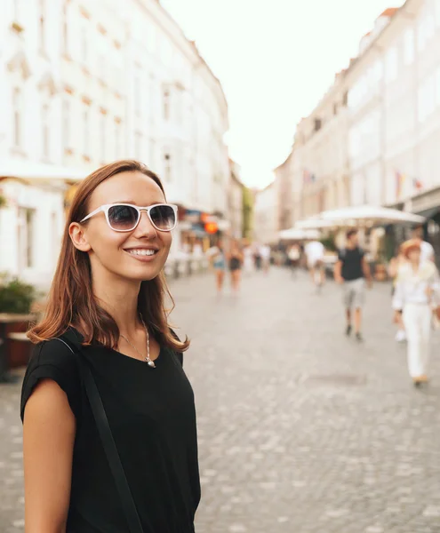 Mulher sorridente no fundo da European Old Town Street — Fotografia de Stock