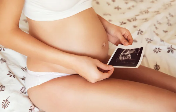 Mulher grávida segurando imagem de ultra-som — Fotografia de Stock