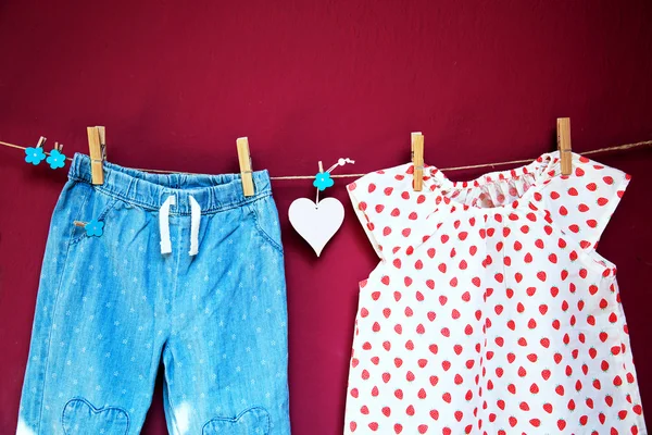 Babykläder och varor som hänger på klädstreck. — Stockfoto