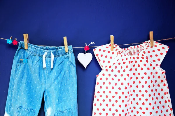 Vestiti e merci per bambini appesi alla clothesline . — Foto Stock