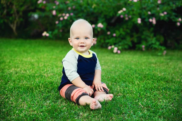 草の上に座って幸せなかわいい男の子 — ストック写真