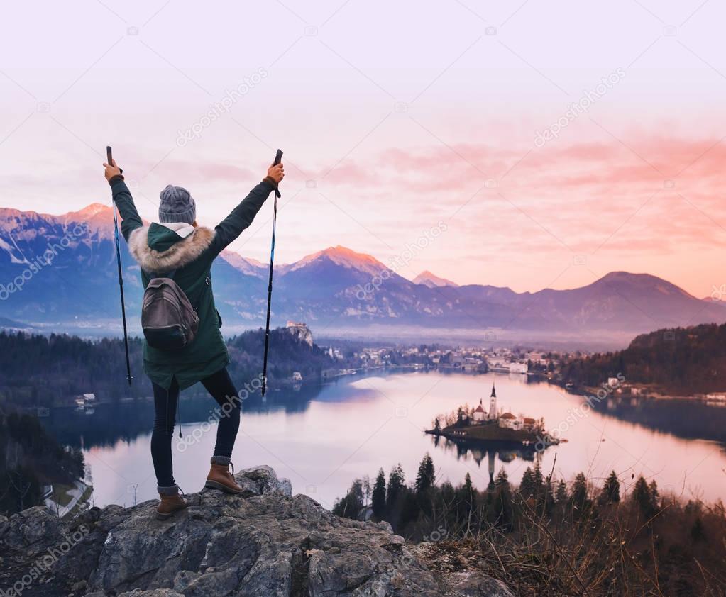 Traveling young woman looking on sunset on Bled Lake, Slovenia, Europe.