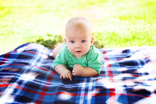 Mignon enfant bébé garçon couché sur couverture en été jour sur la nature — Photo