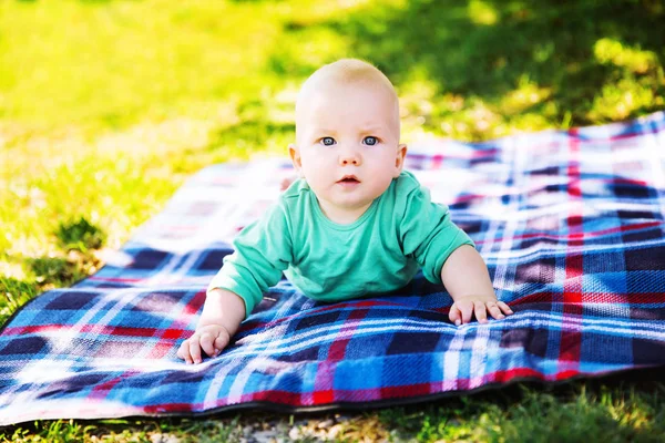 Mignon enfant bébé garçon couché sur couverture en été jour sur la nature — Photo