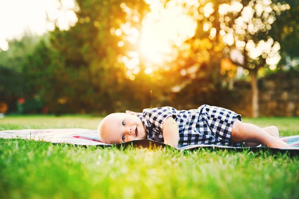 Cute adorable child boy lying on the grass on nature — стоковое фото