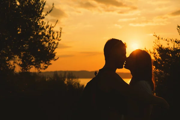 Para całuje się na zachód słońca nad jeziorem Garda, Włochy. — Zdjęcie stockowe