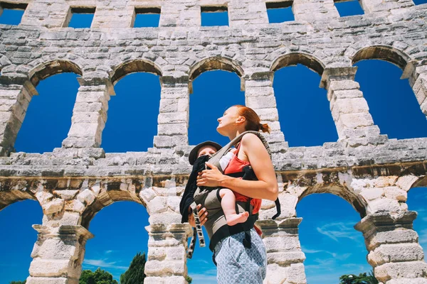 Mother with baby in carrier in the old town of Pula, Croatia. — Stock Photo, Image