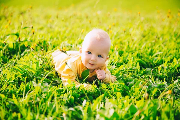 Criança feliz deitada na grama no dia de verão . — Fotografia de Stock