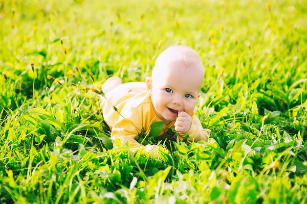 Bébé enfant heureux couché sur l'herbe dans la journée d'été . — Photo