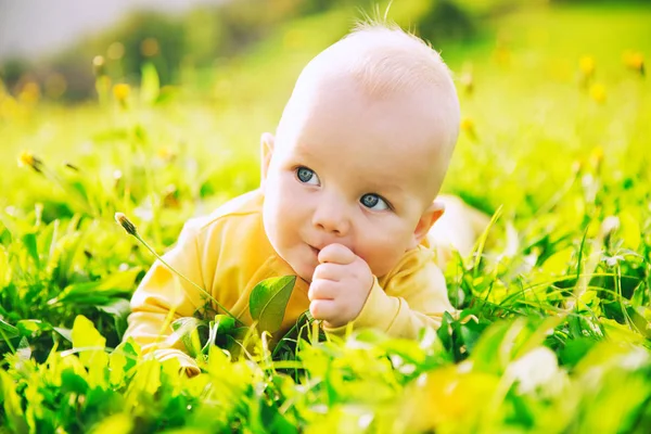 Bébé enfant heureux couché sur l'herbe dans la journée d'été . — Photo