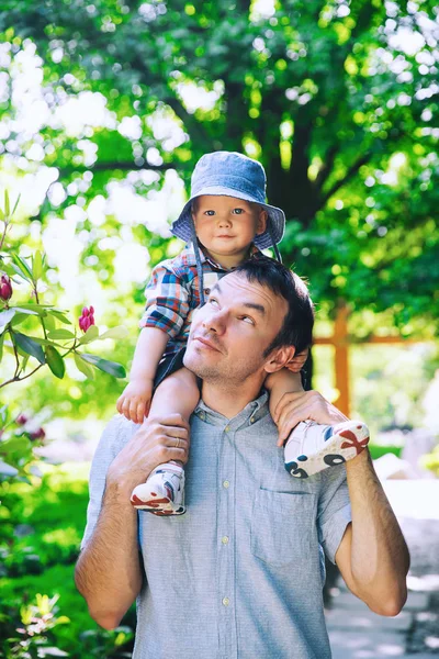 Vader en zoon in het park bij de lentetijd op de achtergrond van — Stockfoto