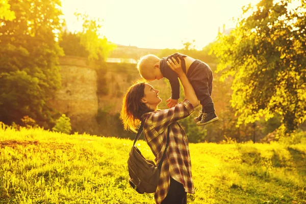 Silhouette d'une jeune mère et de son petit fils au coucher du soleil — Photo