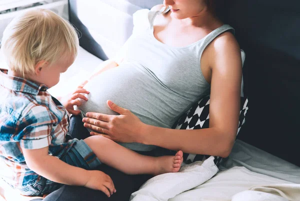 W ciąży matka i syn w domu. — Zdjęcie stockowe