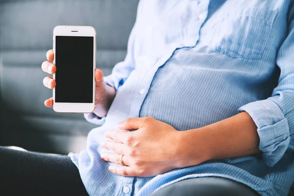 Donna incinta che tiene e mostra il telefono cellulare con display vuoto — Foto Stock