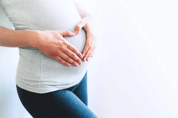 Närbild gravid kvinna på en vit bakgrund. — Stockfoto