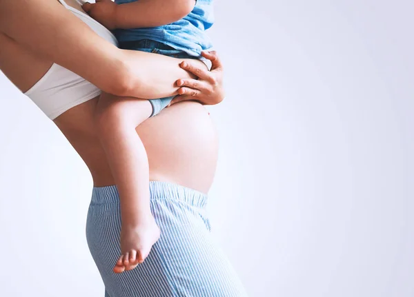 Gravid mamma och son hemma. — Stockfoto