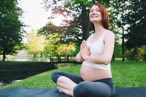 Piękna kobieta w ciąży robi Prenatalna Joga na na zewnątrz natura. — Zdjęcie stockowe