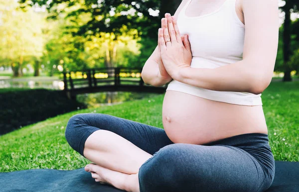 Vacker gravid kvinna gör prenatal yoga på naturen utomhus. — Stockfoto