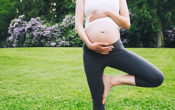 Piękna kobieta w ciąży robi Prenatalna Joga na na zewnątrz natura. — Zdjęcie stockowe