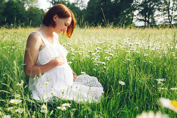 Femeie gravidă pe natură în câmp de mușețel — Fotografie, imagine de stoc