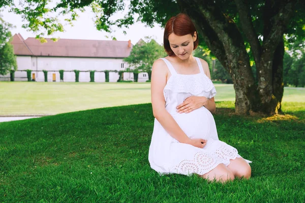 Vacker gravid kvinna i vit klänning på naturen. — Stockfoto