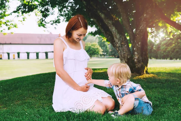 Mujer embarazada con niño en la naturaleza . —  Fotos de Stock