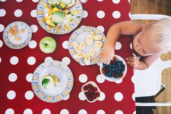 Petit garçon assis à la table, petit déjeuner . — Photo