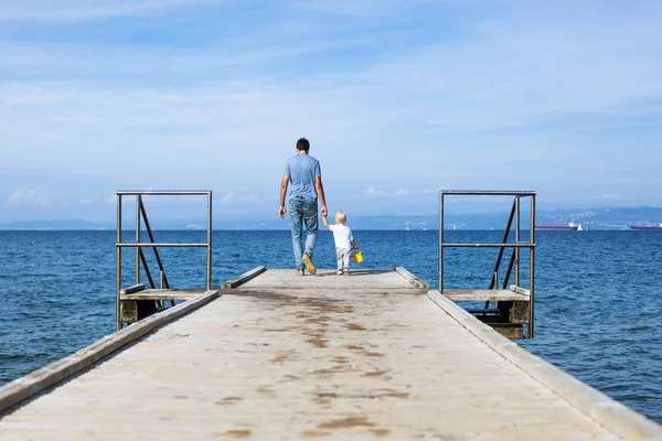 海の桟橋の上を歩いての息子と父. — ストック写真