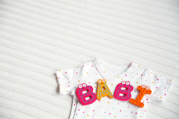 Baby clothes with toy letters - BABY — Stock Photo, Image