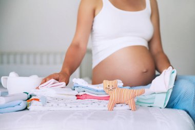 Bebek giysileri, malzeme ve ev iç hamile kadında yığını