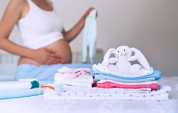 Bebek giysileri, malzeme ve ev iç hamile kadında yığını